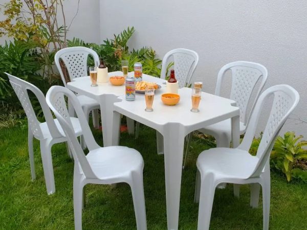 Mesas e cadeiras de plastico em jardim